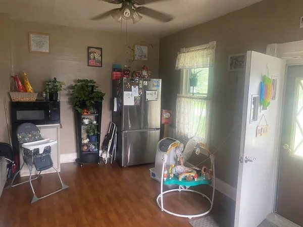 a dining room with furniture potted plants and wooden floor