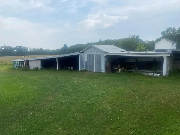 a view of a house with a yard and a large tree front