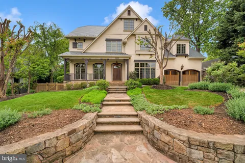 a front view of a house with a yard and potted plants