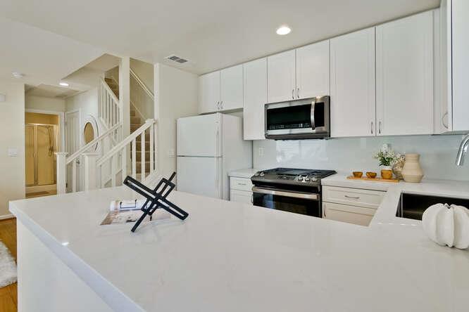 Cottage Court Mountain View, CA 94043 - Photo 12 of 43 a kitchen with stainless steel appliances a stove a sink a refrigerator white cabinets and a refrigerator