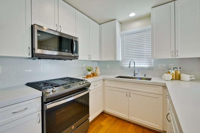 Cottage Court Mountain View, CA 94043 - Photo 14 of 43 a kitchen with stainless steel appliances granite countertop grey cabinets a stove a sink and dishwasher