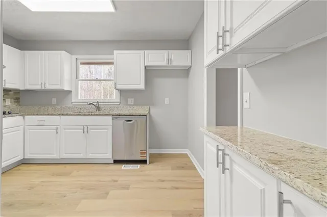 a view of empty room with wooden floor and window