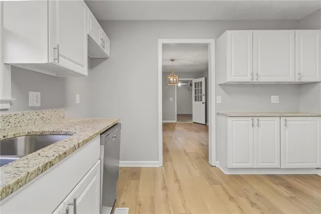 an empty room with wooden floor and ceiling fan
