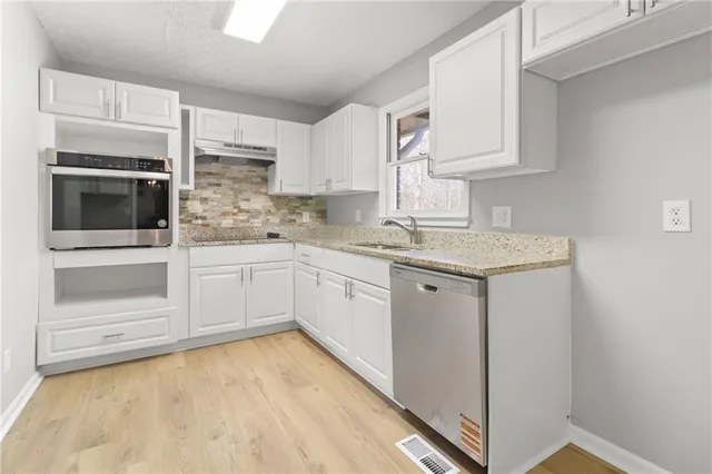 a view of a kitchen with granite countertop cabinets
