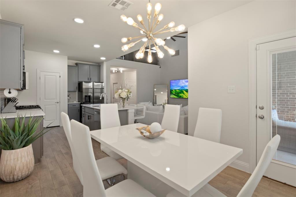 4125 Fern Loop Forney, TX 75126 - Photo 11 of 40 Open-concept dining and kitchen space featuring wood-finish flooring, a contemporary chandelier, recessed lighting, and a kitchen island with sink