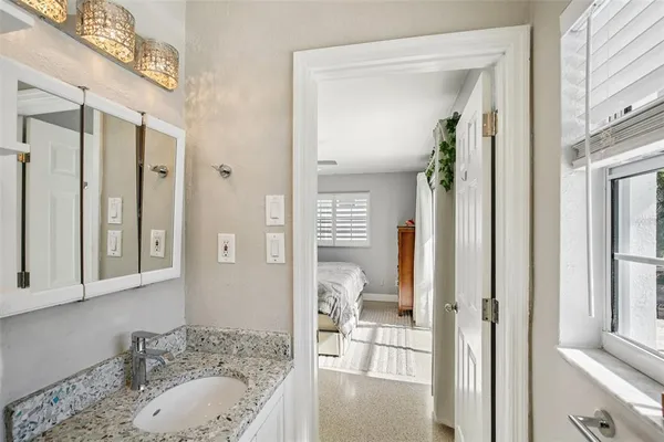 a bathroom with a granite countertop tub sink and mirror