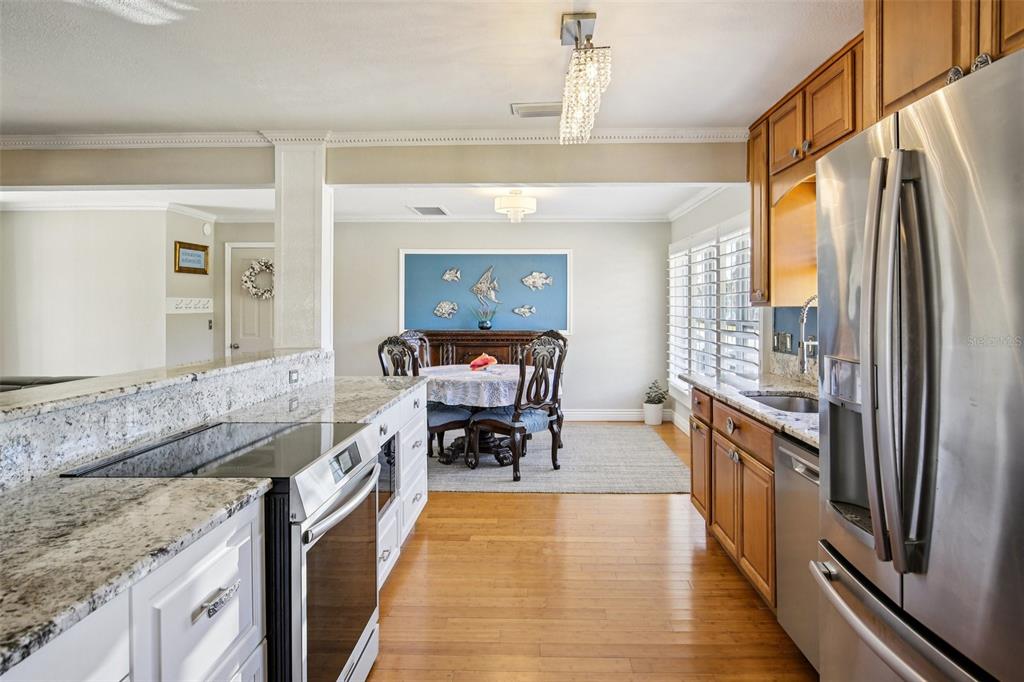 3966 High Bluff Drive Largo, FL 33770 - Photo 27 of 40 a kitchen with stainless steel appliances granite countertop a stove refrigerator and cabinets