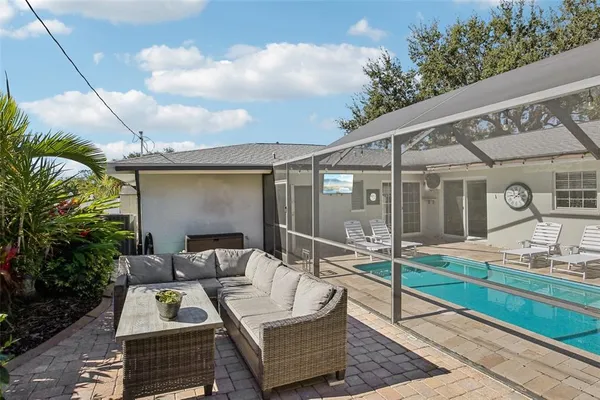 a view of a patio with couches table and chairs and potted plants