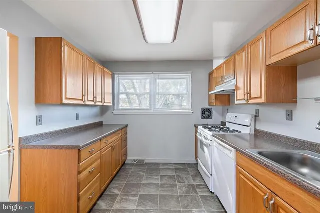 a kitchen with stainless steel appliances granite countertop a sink a stove and a refrigerator
