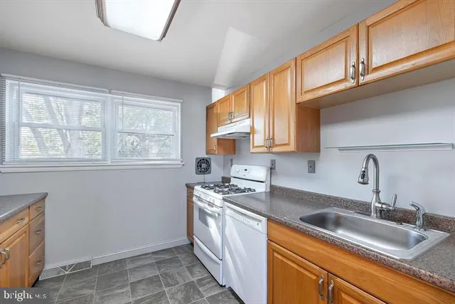a kitchen with stainless steel appliances granite countertop a sink stove and cabinets