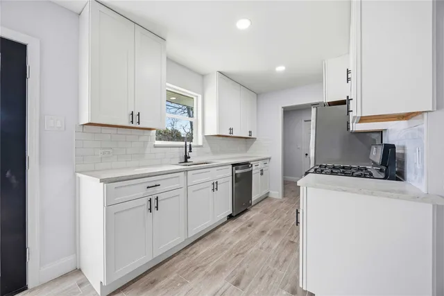 a kitchen with granite countertop cabinets stainless steel appliances and a sink
