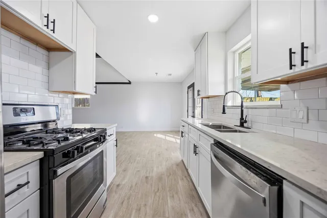a kitchen with stainless steel appliances a sink stove and cabinets