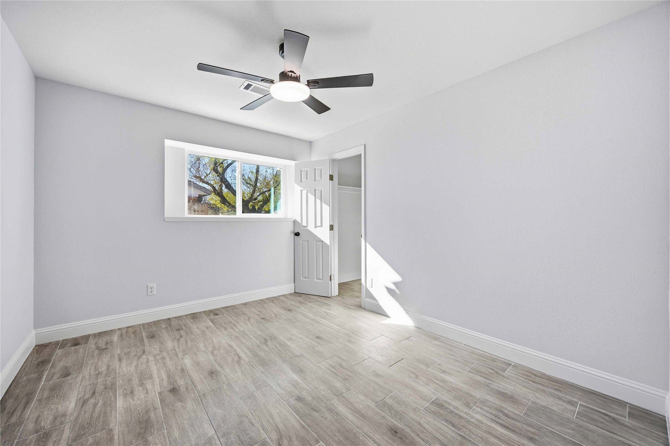 8115 Tarbell Road Houston, TX 77034 - Photo 16 of 24 wooden floor in an empty room with a window