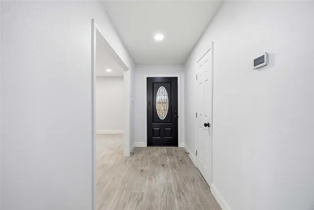 a view of an empty room with wooden floor and cabinet