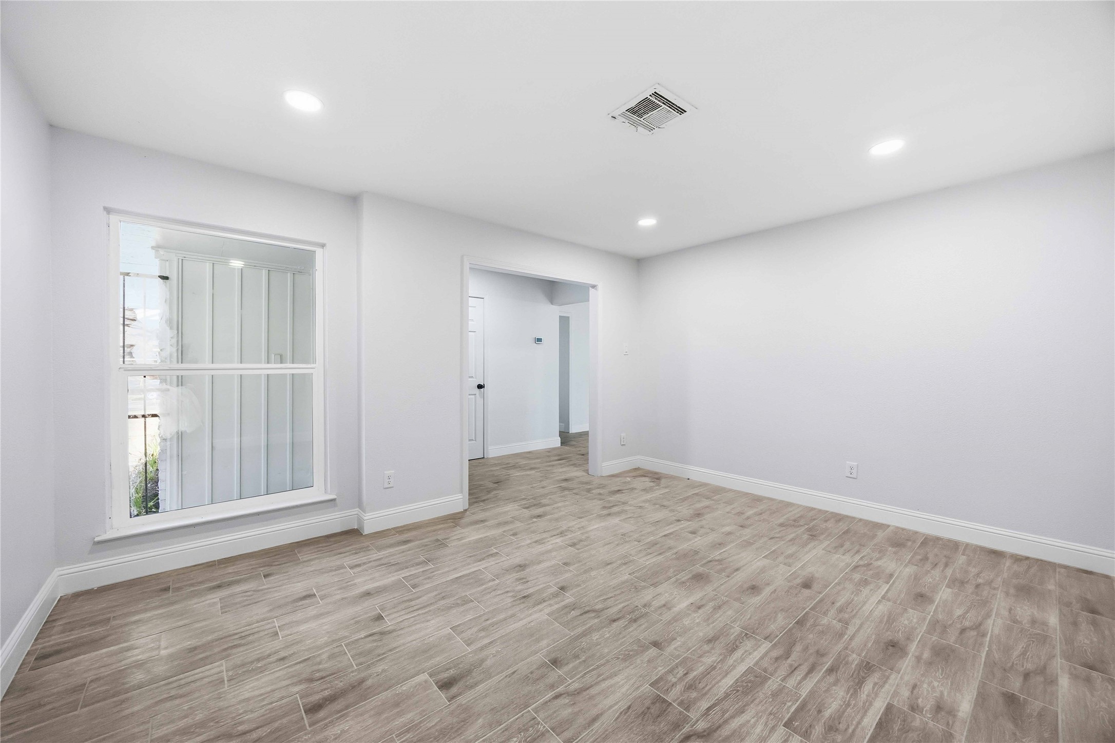 8115 Tarbell Road Houston, TX 77034 - Photo 5 of 24 wooden floor in an empty room with a window