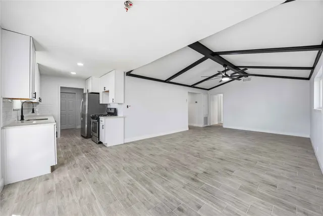 a view of a kitchen with a refrigerator and a stove top oven