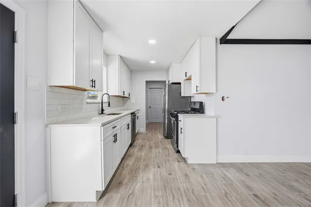 a kitchen with white cabinets and white appliances