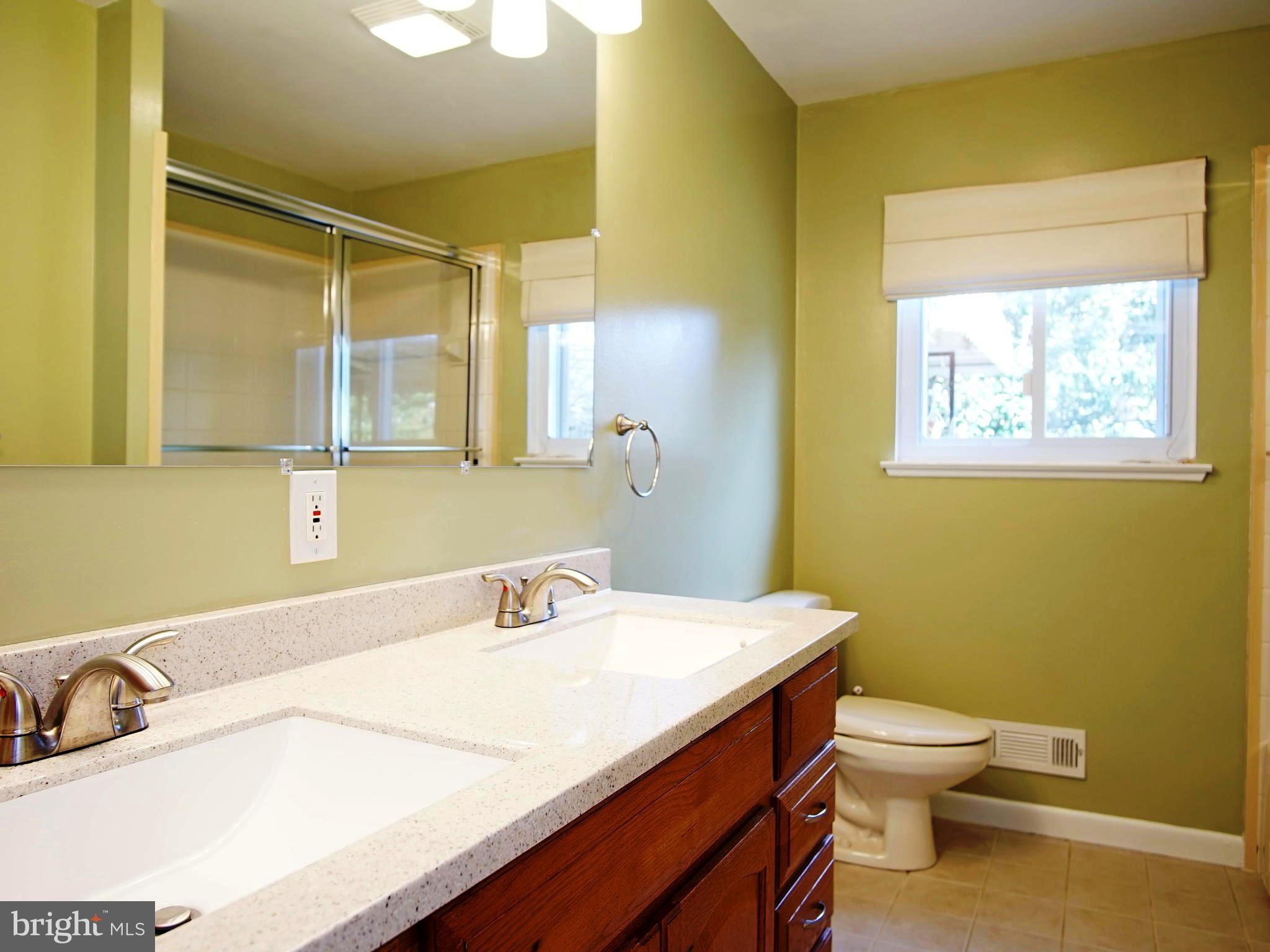 6208 Collinsway Road Baltimore, MD 21228 - Photo 11 of 22 a bathroom with a granite countertop sink a toilet and a mirror