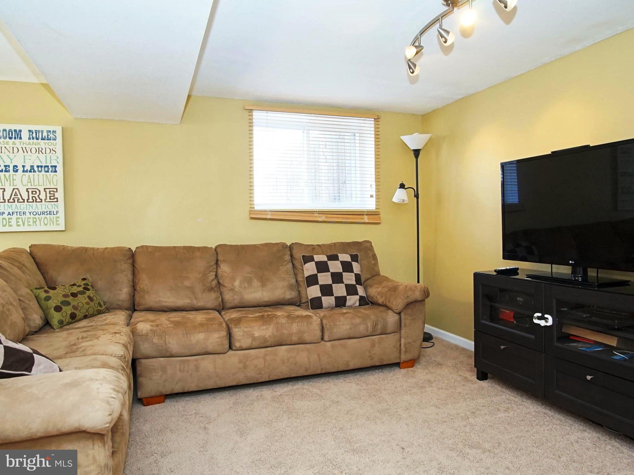 6208 Collinsway Road Baltimore, MD 21228 - Photo 14 of 22 a living room with couches and a flat screen tv