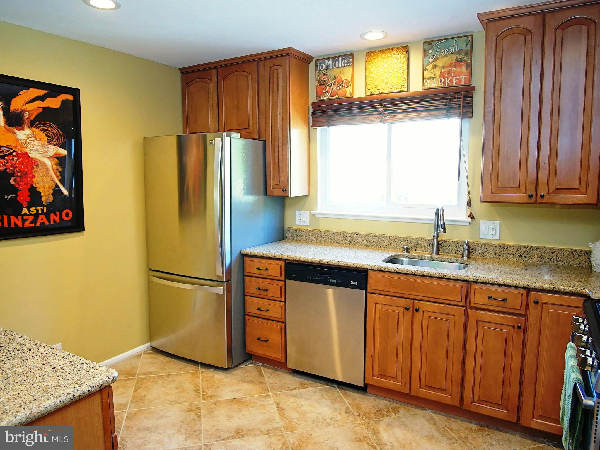 6208 Collinsway Road Baltimore, MD 21228 - Photo 3 of 22 a kitchen with granite countertop a refrigerator and a sink