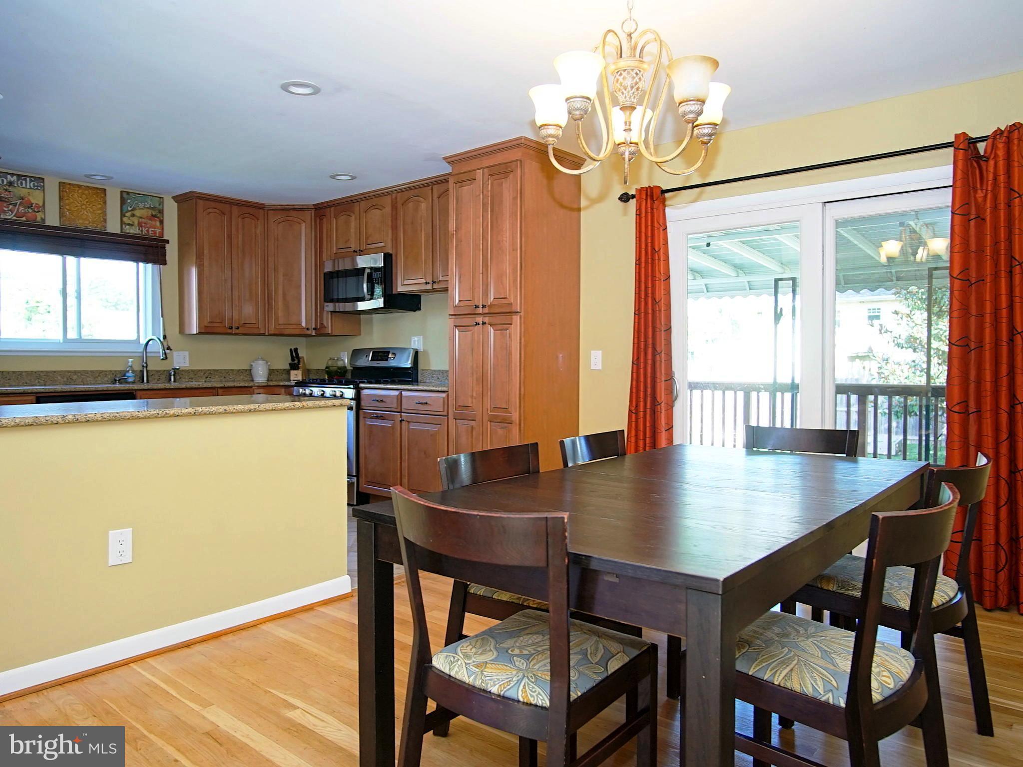 6208 Collinsway Road Baltimore, MD 21228 - Photo 5 of 22 a kitchen with stainless steel appliances granite countertop a table chairs refrigerator and sink