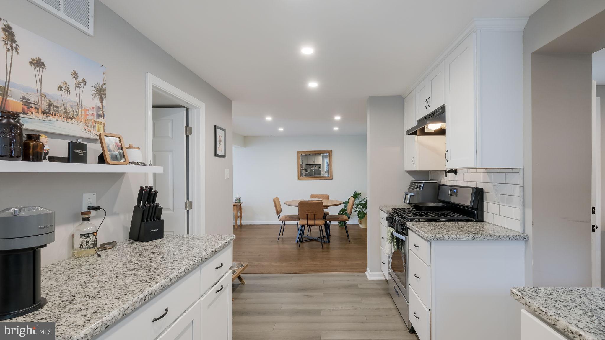 626 Topsfield Road Hatboro, PA 19040 - Photo 7 of 29 a kitchen with stainless steel appliances granite countertop a stove top oven a sink a dining table and chairs with wooden floor