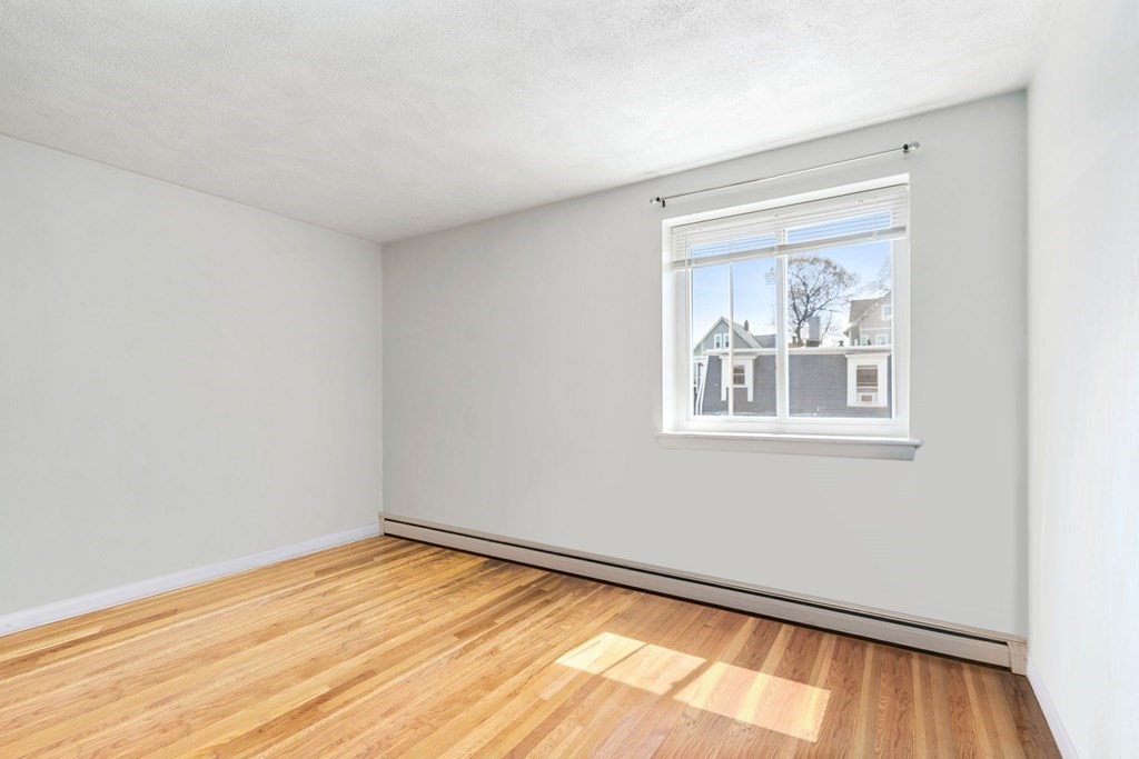 20 Radcliffe Road, Unit 304 Boston, MA 02134 - Photo 20 of 24 a view of an empty room with wooden floor and a window