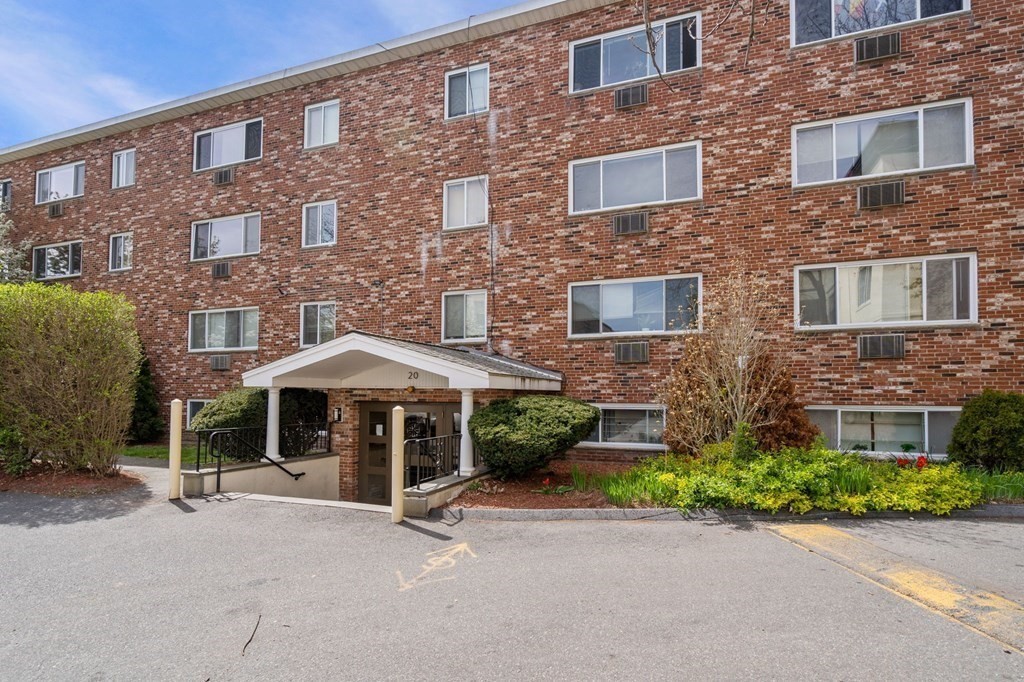 20 Radcliffe Road, Unit 304 Boston, MA 02134 - Photo 7 of 24 a front view of a brick house with a yard and table under an umbrella