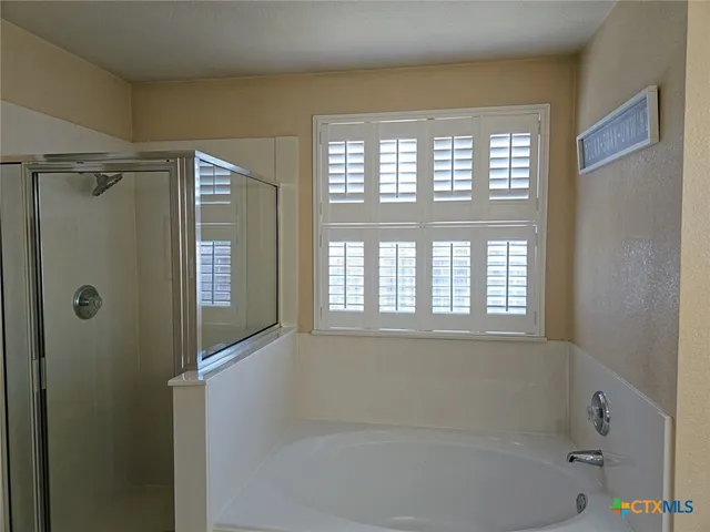 a bathroom with a bathtub next to a window