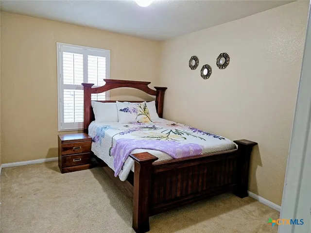 a bed sitting in a bedroom next to a window
