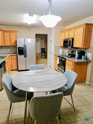 a large kitchen with kitchen island a dining table and chairs