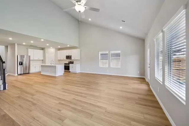 an empty room with wooden floor and windows