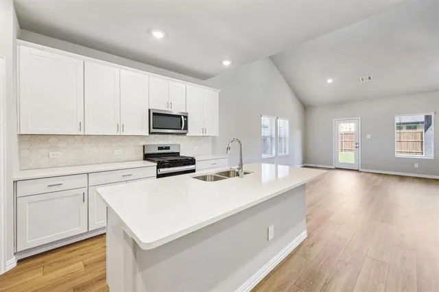 a kitchen with a sink a stove and microwave