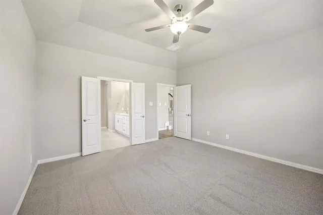 an empty room with a ceiling fan and a window