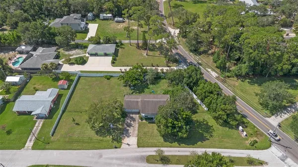 an aerial view of residential houses with outdoor space and street view