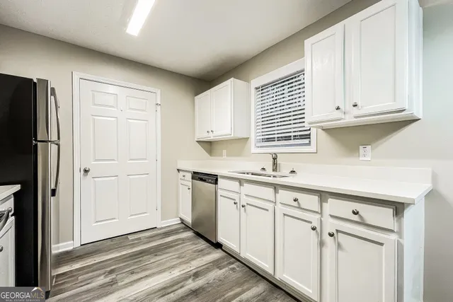 a kitchen with granite countertop white cabinets and white appliances