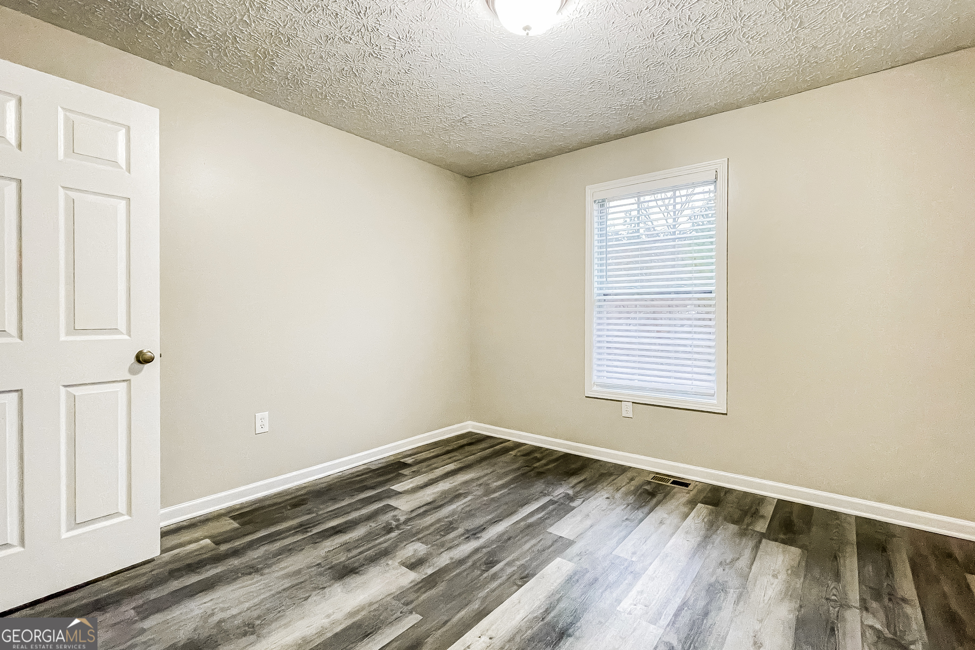 107 Johnny Lane Dallas, GA 30132 - Photo 9 of 17 an empty room with wooden floor and windows
