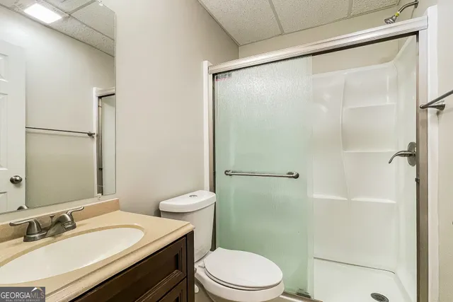 a bathroom with a granite countertop sink toilet and shower