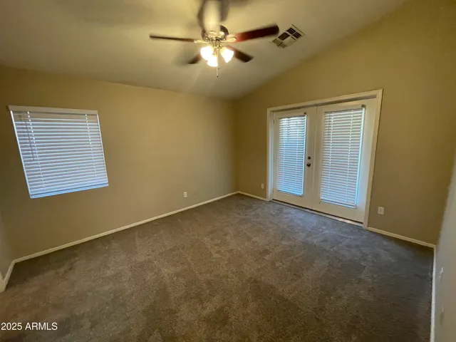 an empty room with a ceiling fan and a window
