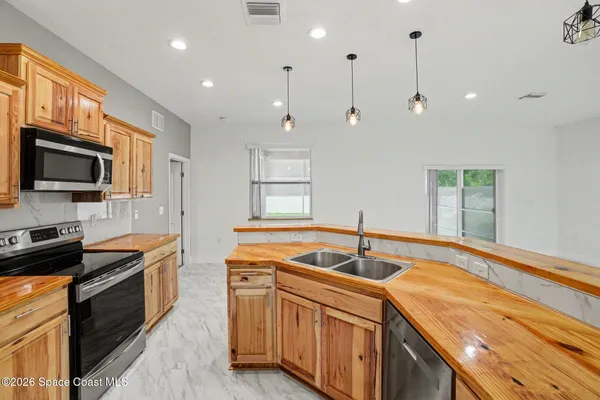 a kitchen with stainless steel appliances granite countertop a sink a stove and a refrigerator