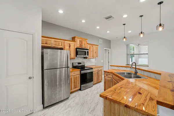 a kitchen with stainless steel appliances granite countertop a refrigerator and a sink