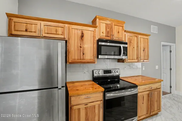 a kitchen with stainless steel appliances granite countertop a refrigerator stove a sink dishwasher and microwave oven