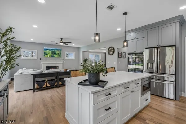 a kitchen with kitchen island white cabinets and stainless steel appliances