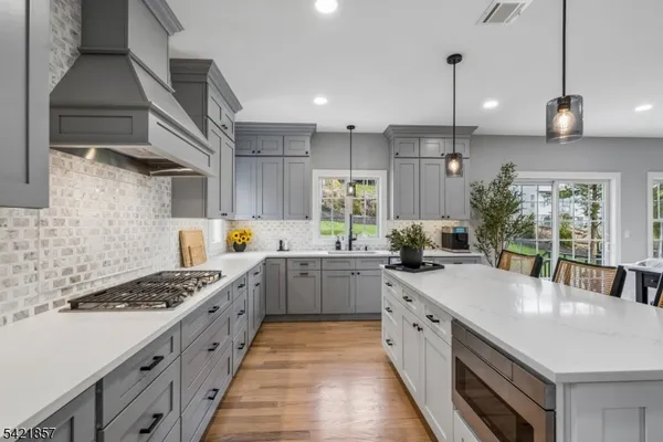 a large kitchen with stainless steel appliances lots of counter space sink and stove