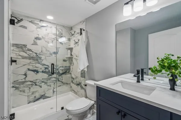 a bathroom with a sink toilet a mirror and shower