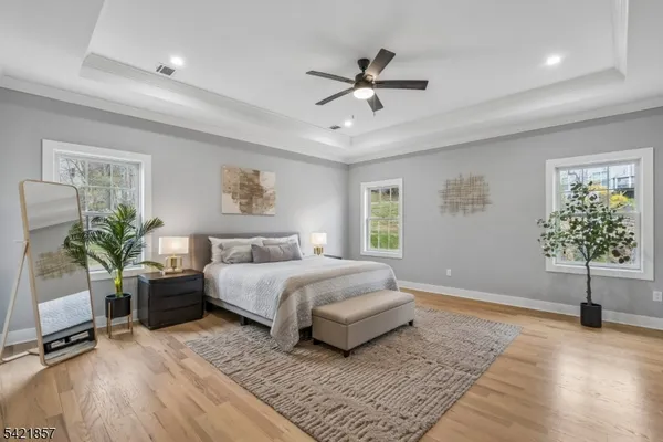 a spacious bedroom with a bed a chandelier and a potted plant