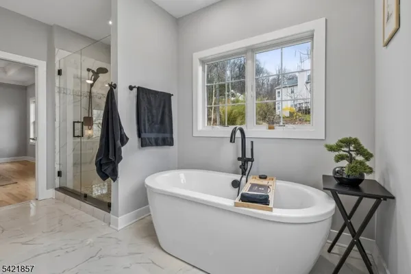 a white bath tub sitting in a bathroom next to a window
