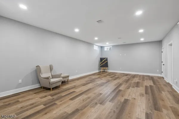 an empty room with wooden floor and chairs