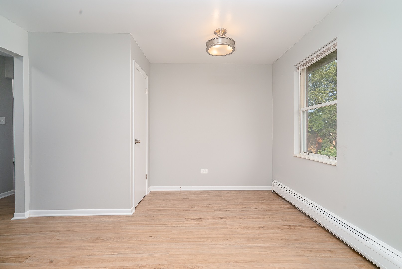 27 South Spring Avenue, Unit 2 La Grange, IL 60525 - Photo 4 of 13 a view of an empty room with wooden floor and a window