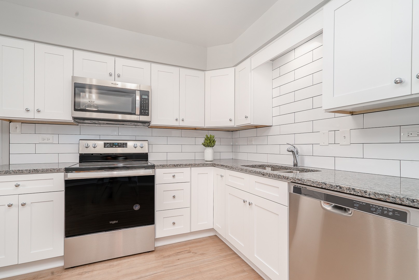 27 South Spring Avenue, Unit 2 La Grange, IL 60525 - Photo 7 of 13 a kitchen with granite countertop white cabinets sink and stainless steel appliances